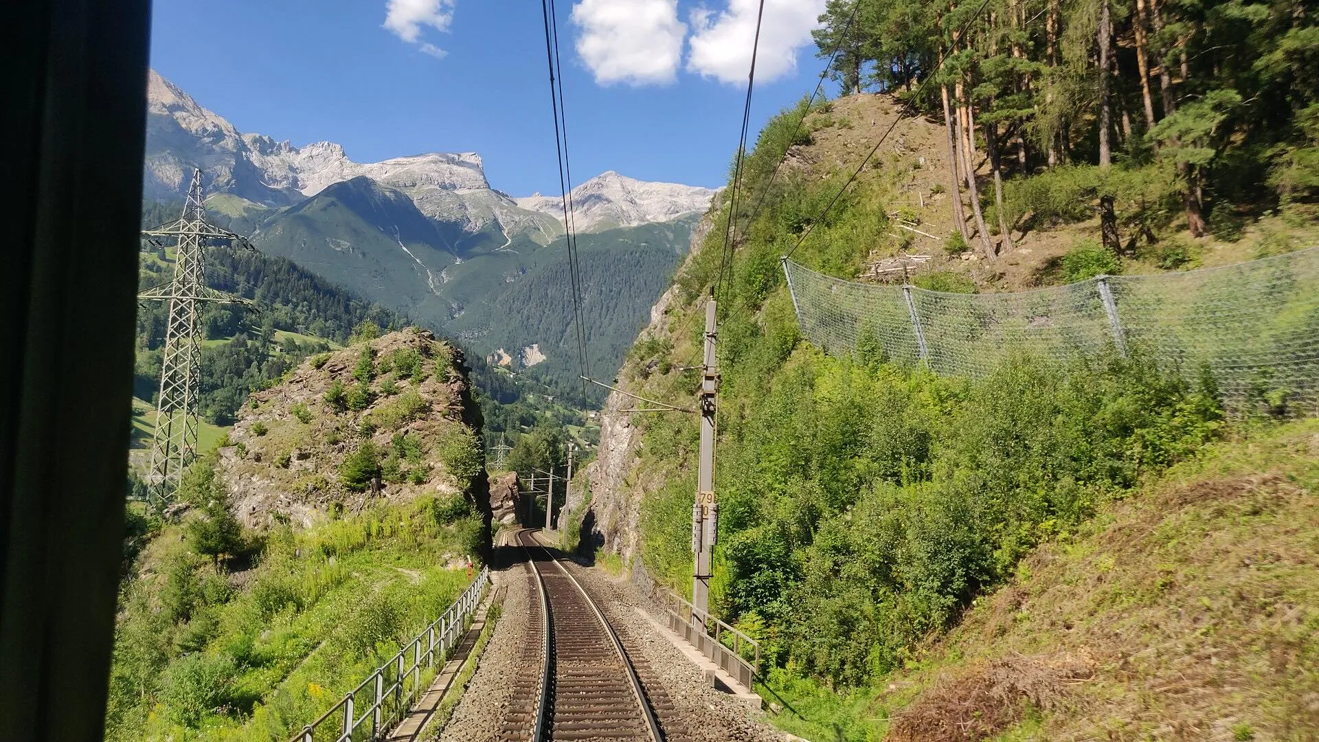 The view from the EC Transalpin cab as the line runs through a rock cutting between wooded slopes.
